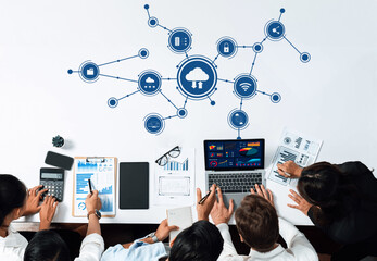 A diverse team collaborates in a modern workspace, surrounded by technology symbols. They analyze data on laptops while leveraging cloud connectivity for enhanced productivity. Amity