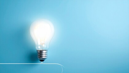 A bright idea illuminated A single glowing lightbulb against a clean blue background