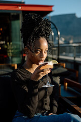 Young woman drinking a cocktail outdoors