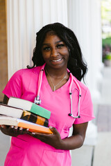 Black medical student grab smiling woman in scrubs with books