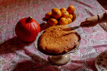Child cutting homemade cake on patterned tablecloth
