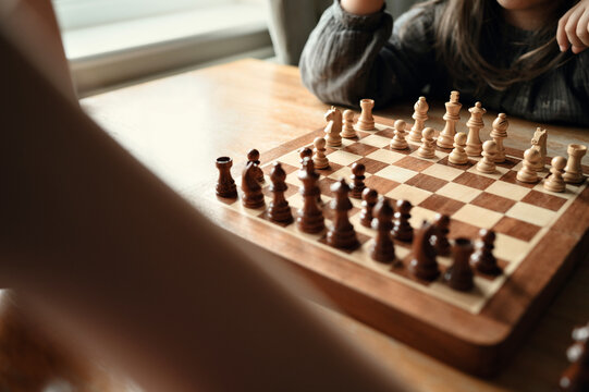 Wooden chessboard with neatly arranged pieces first move done.