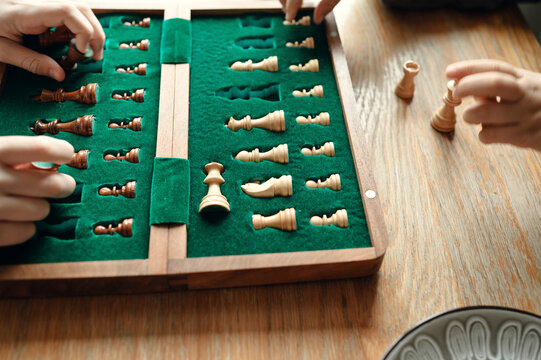 Close-up of wooden chess pieces neatly placed in a green velvet box.