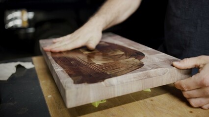 Application of oil finish on cutting board with rich wood