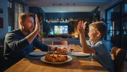 Father and son high fiving at dinner table with fried chicken high five