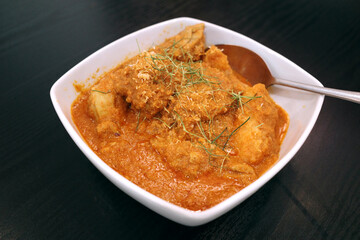 A bowl of traditional curry chicken served in nyonya or peranakan style in Malaysia.