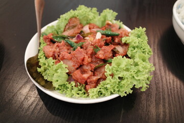 Fried pork with red sauce (cincalok) and fresh cabbage served in nyonya or peranakan style in Malaysia.