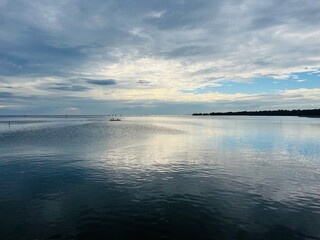 Obraz premium Tranquil Waterscape: Serene waters merge with the sky, under the calm sky, inviting contemplation. A panorama that encapsulates the beauty of nature