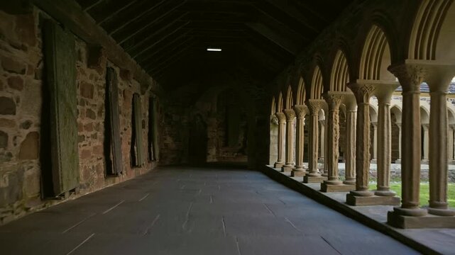 Medieval cloister corridor with stone columns and arches