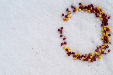 白い木製のテーブルに並べられた赤い金色の雪の結晶のビーズ