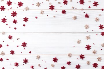 白い木製のテーブルに並べられた赤い金色の雪の結晶のビーズ