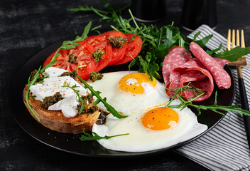 English breakfast. Fried eggs, salami, tomatoes and toast with feta and pesto.