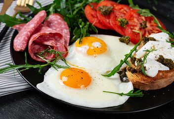 English breakfast. Fried eggs, salami, tomatoes and toast with feta and pesto.
