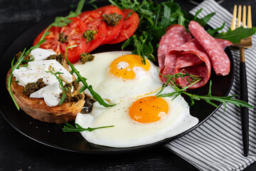 English breakfast. Fried eggs, salami, tomatoes and toast with feta and pesto.