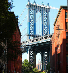 Fototapeta premium iconic view of the manhattan bridge with the empire state building under the tower in the dumbo area of brooklyn new york