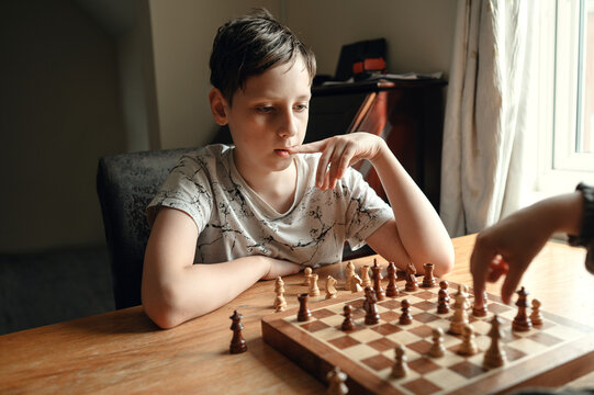 Boy analyzing chessboard and thinking about his next move.