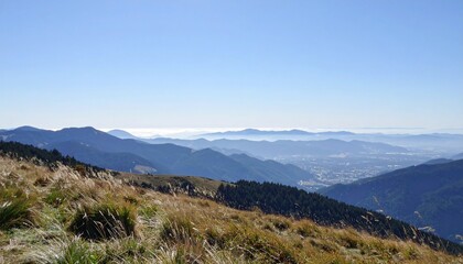 Obraz premium Hilltop overlooking scenic valley with layers of mountains and fog