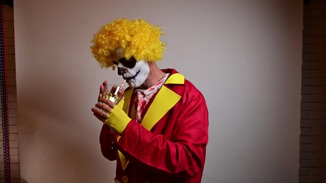 Scary skeleton clown in a yellow wig drinking a cocktail