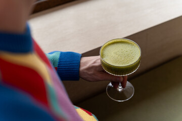 Man drinking Matcha apple nut drink served in elegant glass