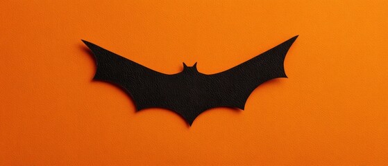 Naklejka premium The Bat Silhouette Cutout on Vibrant Orange Background for Halloween Decoration