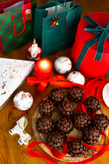 Christmas or New Year sponge cakes cones with holiday gifts, red candle, christmas tree toys and red ribbons