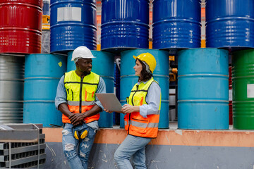 male engineer supervisor discuss progress production plan with technician oil barrel background use computer laptop, team of diverse workers working together at industrial manufacturing factory