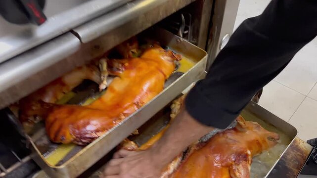 Chef preparing roasted suckling pigs in a restaurant kitchen