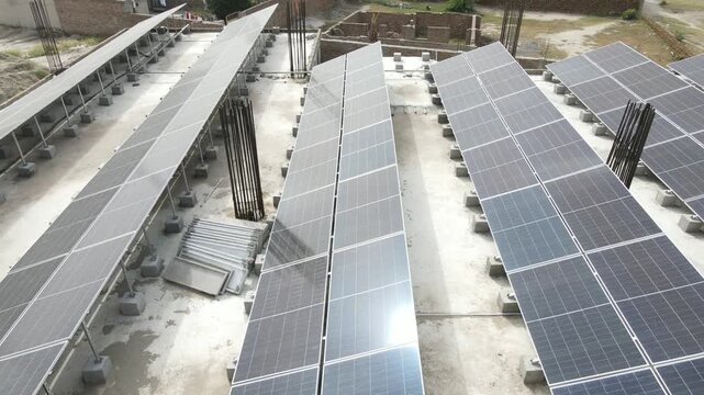 A high-resolution aerial view of a solar power plant with rows of photovoltaic panels and rooftop solar installations capturing sunlight for clean electricity generation, symbolizing green energy and 