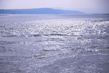 The calm sea surface sparkles with sunshine