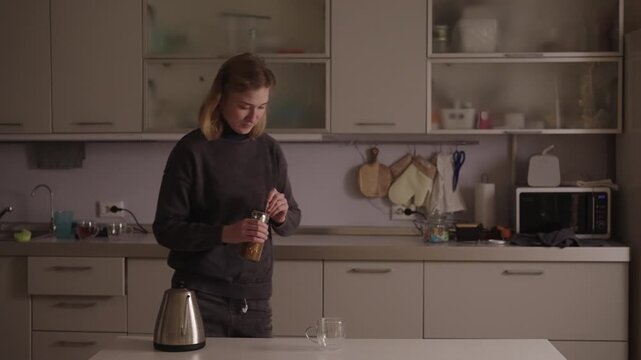 Resilient young woman with cerebral palsy navigating daily routine, carefully preparing cup of coffee in kitchen, showcasing independence and determination despite her disability, slow motion.
