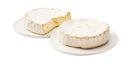 Two wheels of brie cheese on white plates with one wheel having a slice removed from it on white background