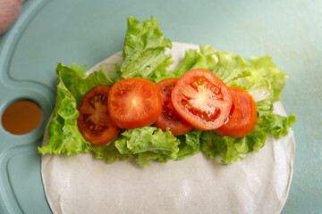 Fresh lettuce and tomato filling on tortilla