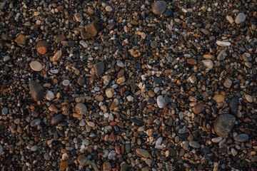 Natural stone backdrop: dark wet pebble beach texture after a wave recedes