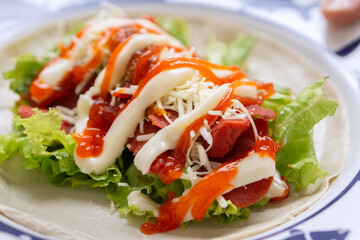 Savory wrap with fresh lettuce, cheese, and sauces