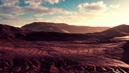 Waves of red terrain stretch across the horizon as soft sunlight casts shadows on the rocky surfaces. Clouds drift overhead, creating a stunning contrast against the warm colors of the landscape.