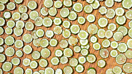 slices of lime on a wooden background, top view.