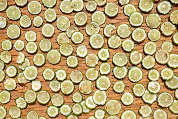 slices of lime on a wooden background, top view.