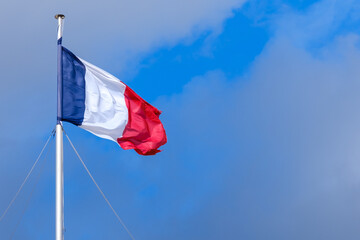 View of the national flag of France and a blue sky in the background