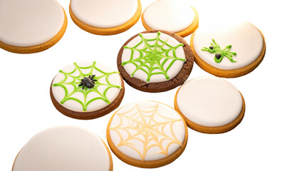 Assorted cookies on black, some decorated with web designs, insect. Bright lighting accentuates texture