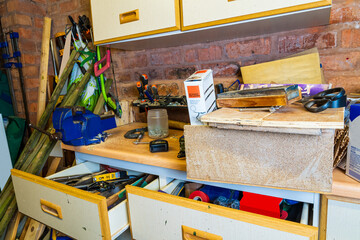 A messy  workbench in a workshop, Untidy workman leaves tools all over work surface