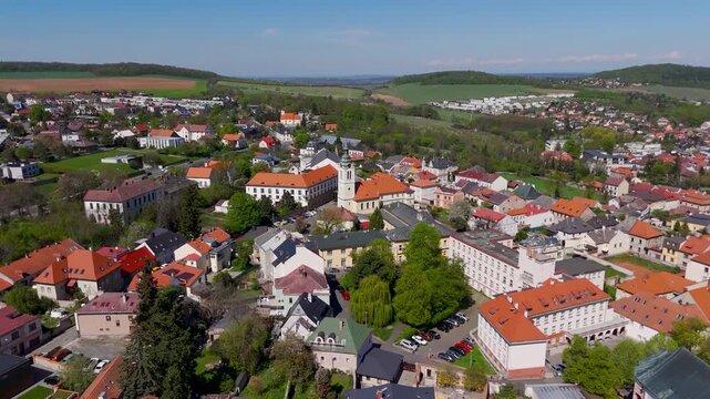 Cinematic aerial drone dolly shot approaching the historic Church of St. Bartholomew, highlighting the white tower and spire in Kutna Hora, Czechia.