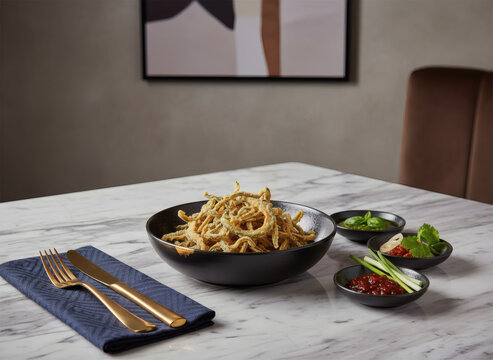 Crispy Indonesian Eel Chips (Keripik Belut) seasoned with garlic and coriander, served on a wooden plate with gold cutlery on a dark table