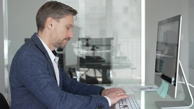 Businessman in a blue jacket thinking and brainstorming ideas while working on computer and taking notes in modern office. Business people concept
