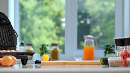 Bright kitchen scene with food ingredients for breakfast on a countertop, ready for cooking.