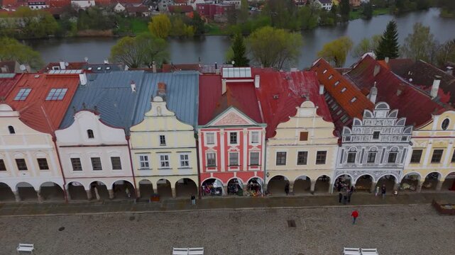 Aerial drone pan over the highly ornate gables of colorful Italian Renaissance houses lining Zacharias of Hradec Square, Telč, UNESCO World Heritage Site, Czechia.