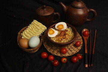 a bowl of boiled noodles with salted eggs