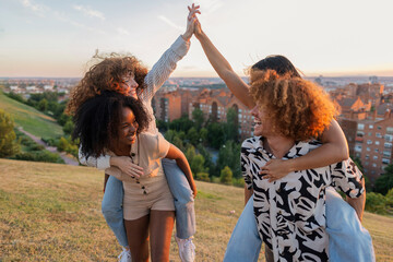Diverse friends doing piggyback ride giving high five