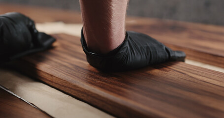 woodworker applying oil finish to black walnut board
