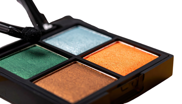 Close-up of a colorful quad eyeshadow palette with applicators, showcasing blue, green, bronze, and orange shades