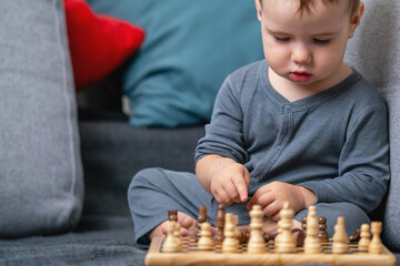 Baby boy thinking over his next chess move. Copy space for text or design.